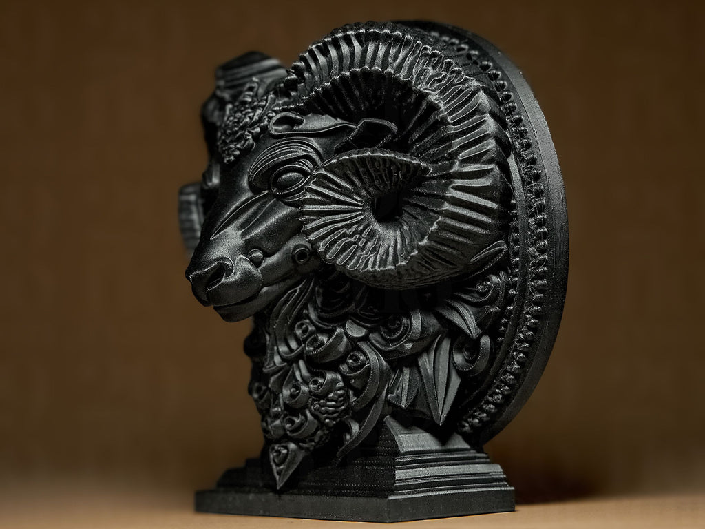 Decorative black ram head sculpture on a brown background