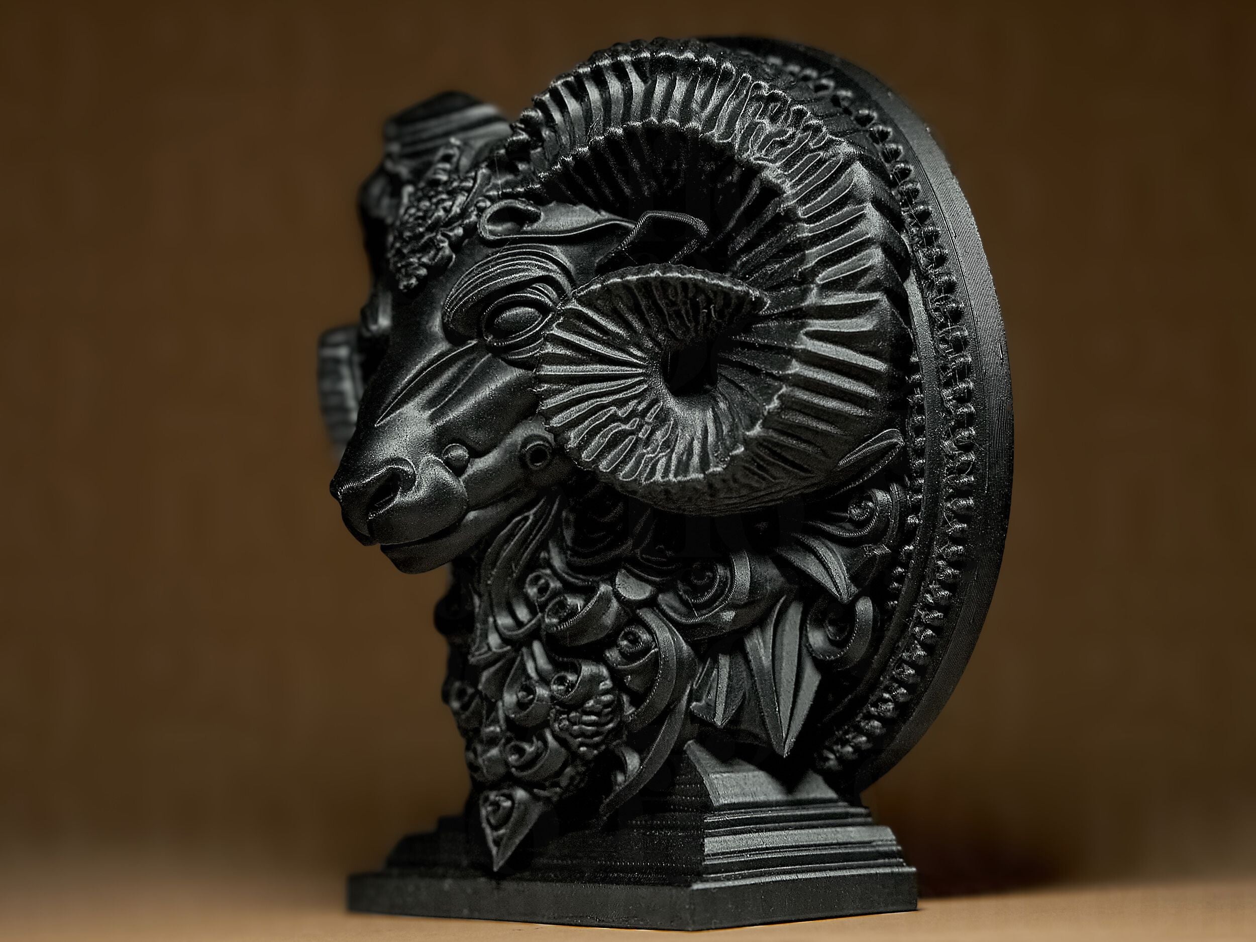 Decorative black ram head sculpture on a brown background