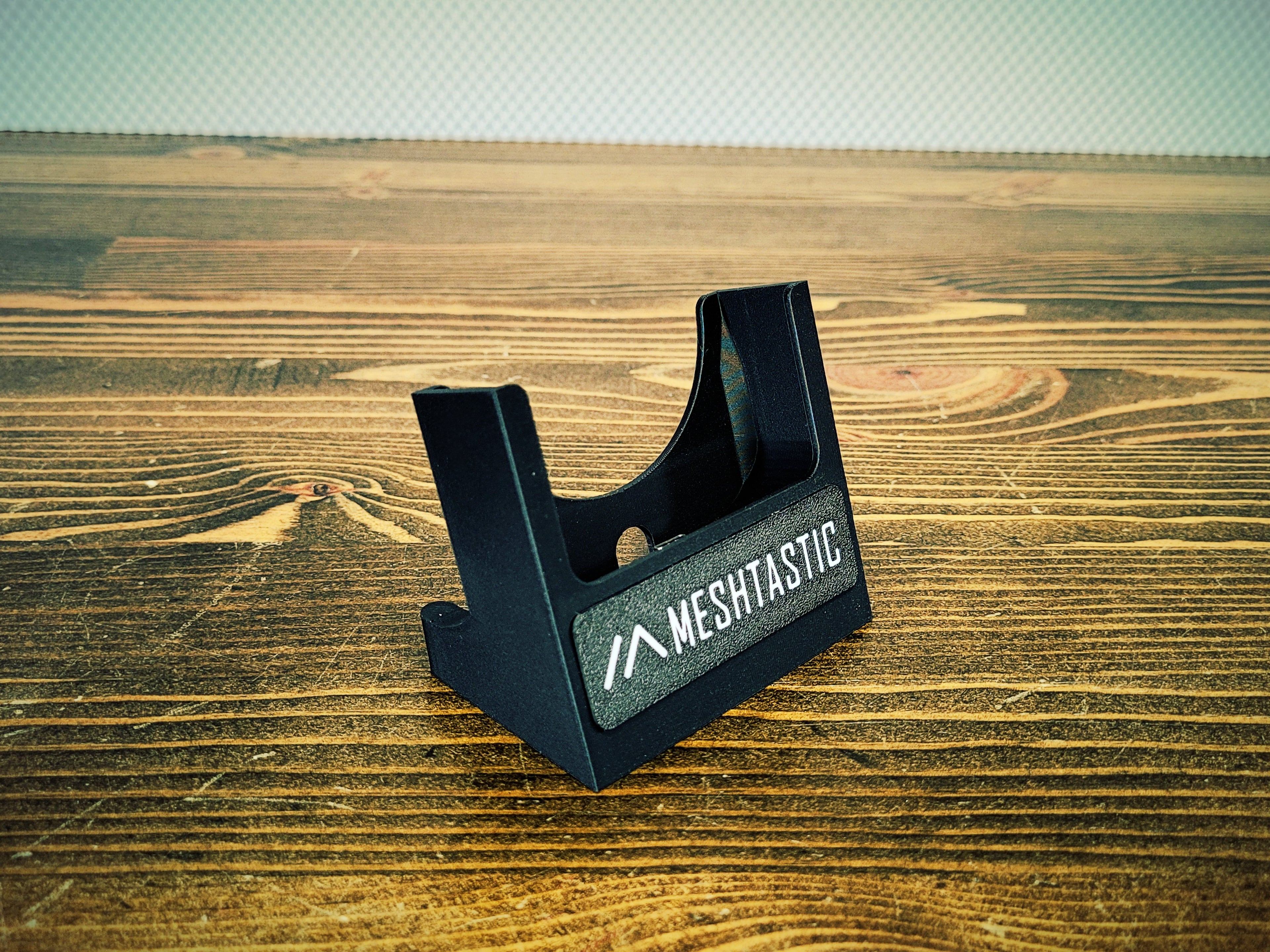 Black stand with 'MESHTASTIC' branding on a wooden surface